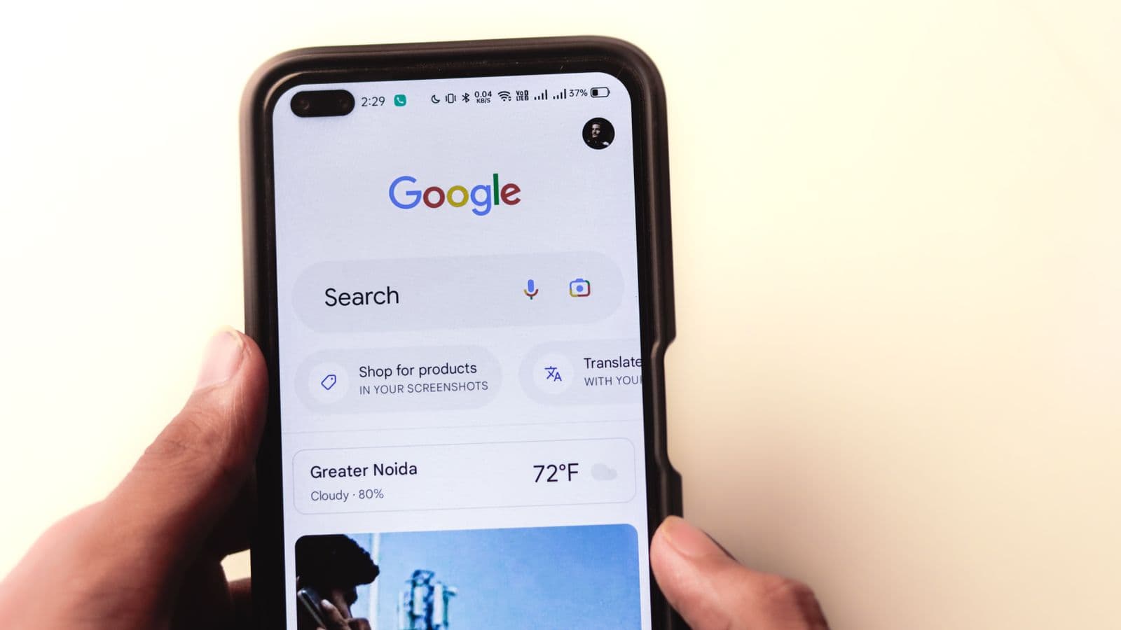 Hand holding a smartphone with Google Search open